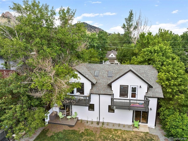 exterior space with a shingled roof and a mountain view