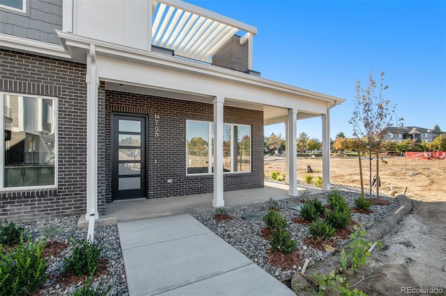 entrance to property with brick siding and covered porch