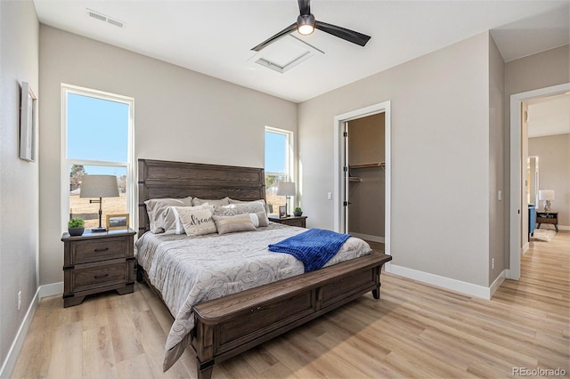 bedroom with visible vents, light wood-style flooring, attic access, and baseboards