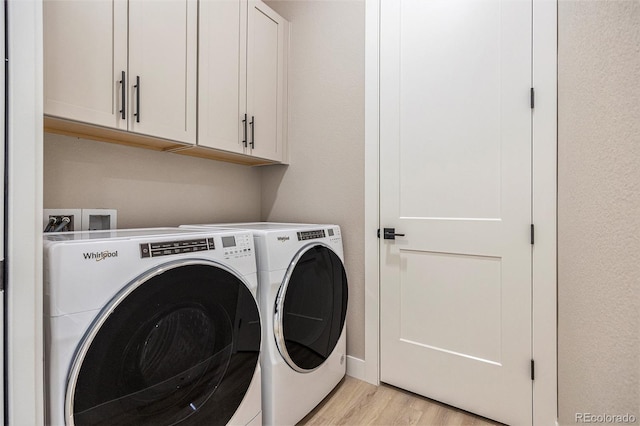 laundry room with cabinet space, light wood-style floors, and washing machine and clothes dryer