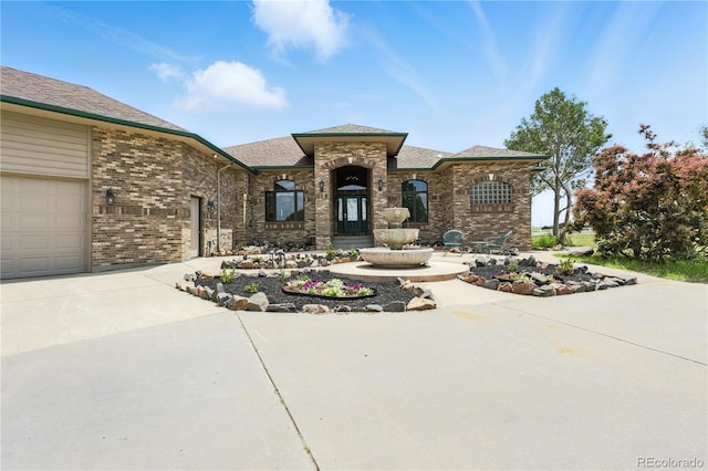 31200 E 145th Ave, Brighton, CO 80603 - french country style house featuring concrete driveway, brick siding, an attached garage, and a shingled roof