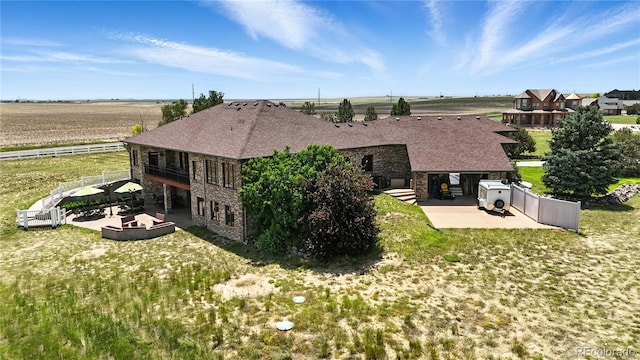 31200 E 145th Ave, Brighton, CO 80603 - rear view of property with a patio, stone siding, and a shingled roof