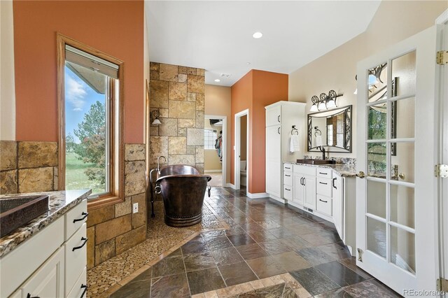 31200 E 145th Ave, Brighton, CO 80603 - bathroom with stone tile flooring, vanity, and a freestanding bath