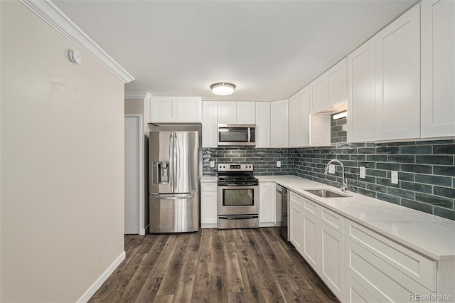 3460 S Poplar St Unit 404, Denver, CO 80224 - kitchen featuring appliances with stainless steel finishes, a sink, light countertops, backsplash, and white cabinetry
