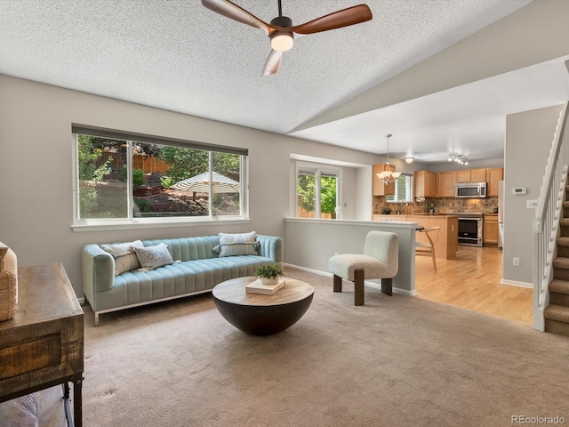2548 Foothills Canyon Ct, Highlands Ranch, CO 80129 - living area featuring light carpet, a ceiling fan, stairs, a textured ceiling, and lofted ceiling