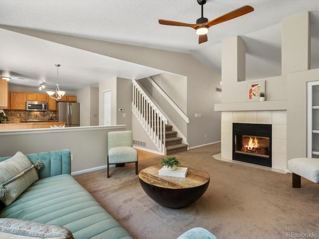 2548 Foothills Canyon Ct, Highlands Ranch, CO 80129 - living room featuring carpet flooring, vaulted ceiling, a tiled fireplace, stairway, and a ceiling fan