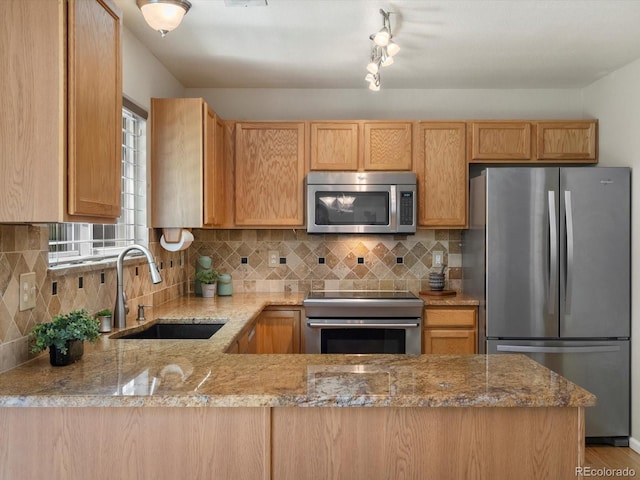 2548 Foothills Canyon Ct, Highlands Ranch, CO 80129 - kitchen with stainless steel appliances, light brown cabinetry, decorative backsplash, and light stone counters