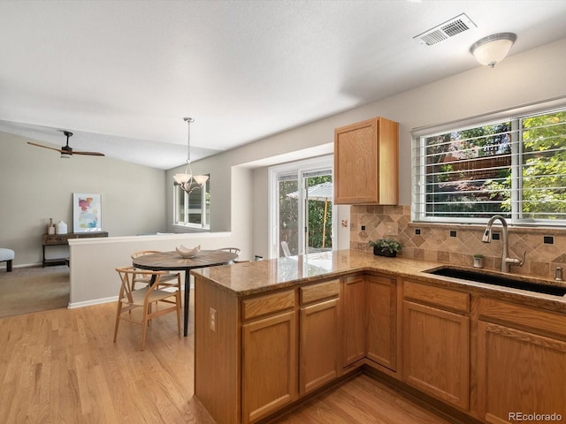 2548 Foothills Canyon Ct, Highlands Ranch, CO 80129 - kitchen featuring tasteful backsplash, pendant lighting, a peninsula, light wood finished floors, and light stone countertops
