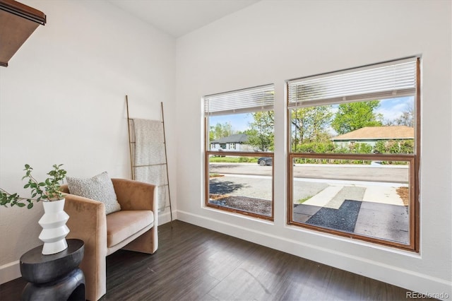 living area featuring baseboards and dark wood finished floors