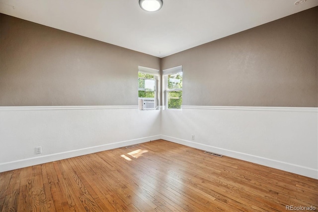spare room with baseboards, hardwood / wood-style flooring, and cooling unit