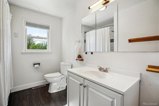 full bathroom with baseboards, wood finished floors, toilet, and vanity