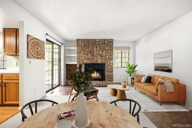 12560 E Warren Dr Unit E, Aurora, CO 80014 - living area with a stone fireplace, a textured ceiling, and a healthy amount of sunlight