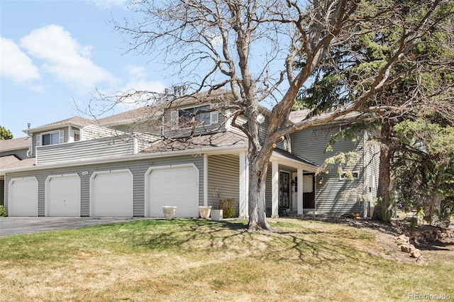 view of front of home featuring roof with shingles, driveway, and a front yard