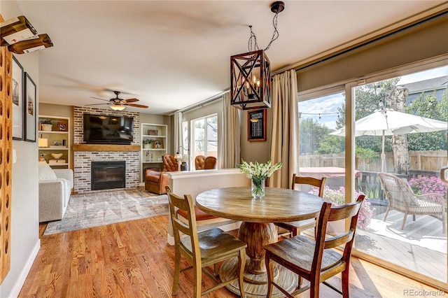 5397 S Killarney St, Centennial, CO 80015 - dining room with a fireplace, light wood finished floors, ceiling fan, and built in features