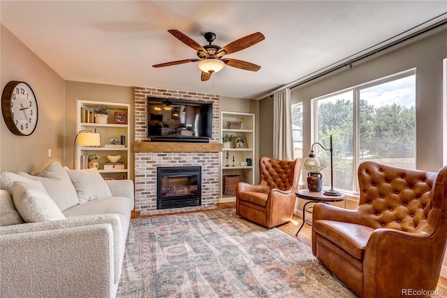 5397 S Killarney St, Centennial, CO 80015 - living area with built in shelves, a ceiling fan, a brick fireplace, and wood finished floors