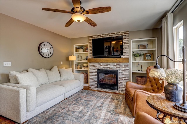 5397 S Killarney St, Centennial, CO 80015 - living room with built in shelves, a ceiling fan, a fireplace, and wood finished floors