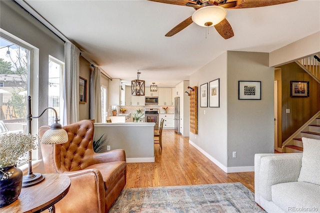 5397 S Killarney St, Centennial, CO 80015 - living room featuring stairs, a ceiling fan, light wood-style floors, and a chandelier