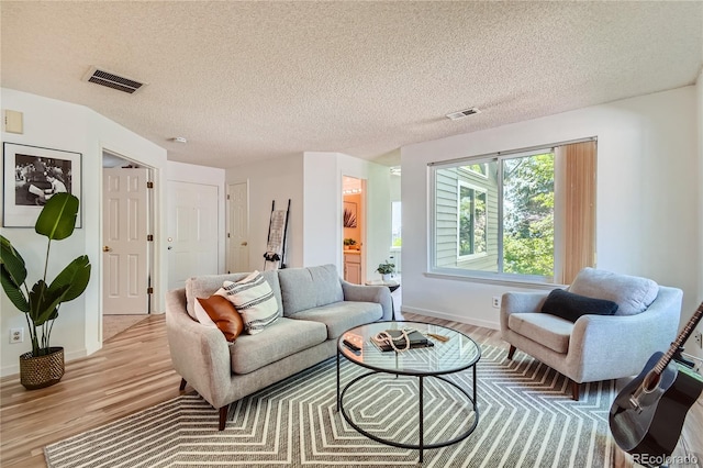 living room featuring a textured ceiling and light hardwood / wood-style flooring