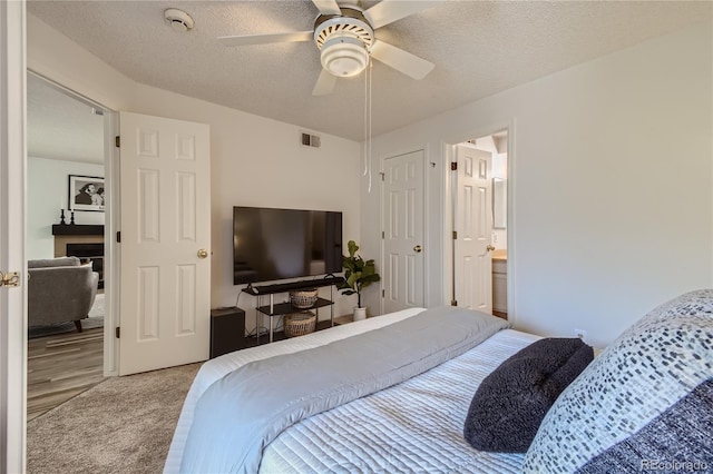 bedroom with connected bathroom, ceiling fan, a textured ceiling, and hardwood / wood-style flooring