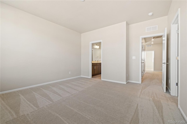 unfurnished bedroom with light colored carpet and ensuite bath