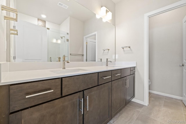 bathroom with tile patterned flooring, vanity, toilet, and a shower with shower door