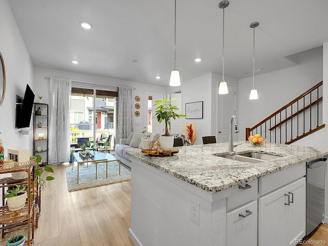 7488 W Pacific Ln, Denver, CO 80227 - kitchen with recessed lighting, white cabinetry, light wood-type flooring, stainless steel dishwasher, and an island with sink