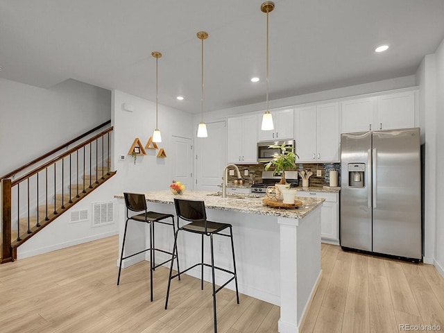 7488 W Pacific Ln, Denver, CO 80227 - kitchen featuring stainless steel appliances, light wood-type flooring, white cabinetry, and recessed lighting