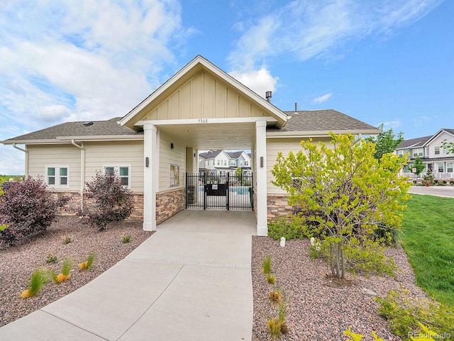 7488 W Pacific Ln, Denver, CO 80227 - view of front facade featuring stone siding, board and batten siding, a gate, and concrete driveway