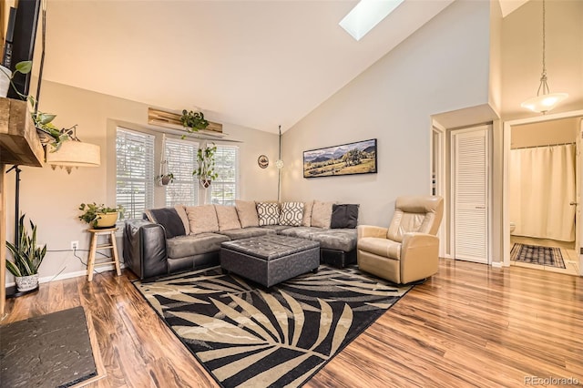 living room with baseboards, high vaulted ceiling, wood finished floors, and a skylight