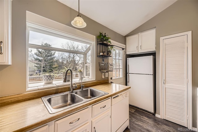 kitchen with white cabinets, hanging light fixtures, a sink, white appliances, and lofted ceiling