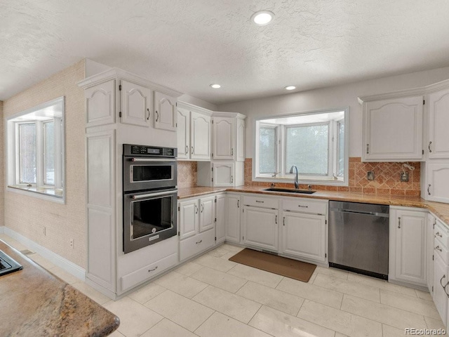 kitchen with stainless steel appliances, sink, and white cabinets