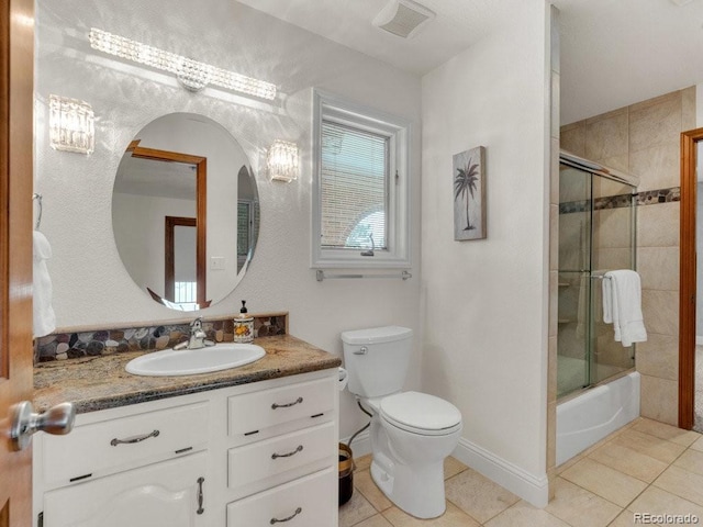 full bathroom featuring vanity, tile patterned floors, shower / bath combination with glass door, and toilet