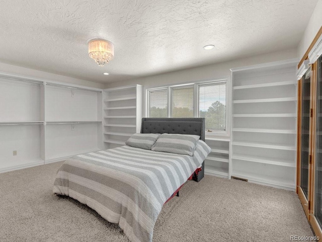 carpeted bedroom featuring a textured ceiling