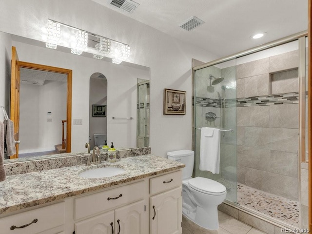 bathroom featuring vanity, an enclosed shower, tile patterned floors, and toilet