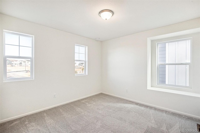 carpeted spare room featuring a wealth of natural light