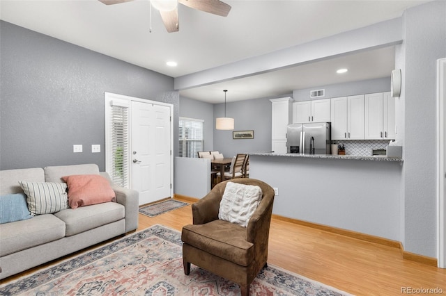 living area with a ceiling fan, light wood-type flooring, recessed lighting, and a textured wall