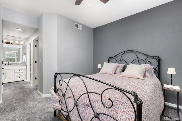 carpeted bedroom featuring baseboards, connected bathroom, and a ceiling fan