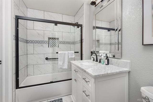 bathroom featuring bath / shower combo with glass door, vanity, marble finish flooring, toilet, and a textured wall
