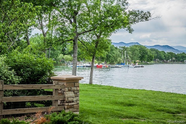 water view with a mountain backdrop and a dock