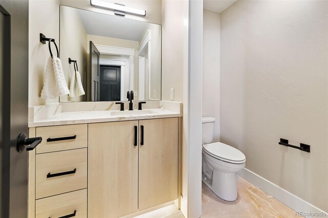 bathroom with tile patterned flooring, vanity, and toilet