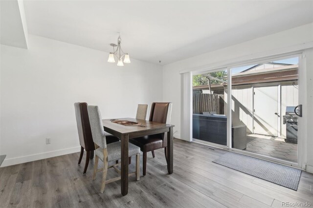 12455 W Alameda Dr, Lakewood, CO 80228 - dining area featuring a chandelier, wood finished floors, and baseboards
