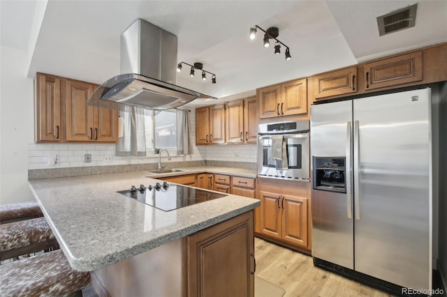 12455 W Alameda Dr, Lakewood, CO 80228 - kitchen with appliances with stainless steel finishes, island range hood, a sink, a peninsula, and light wood-style floors