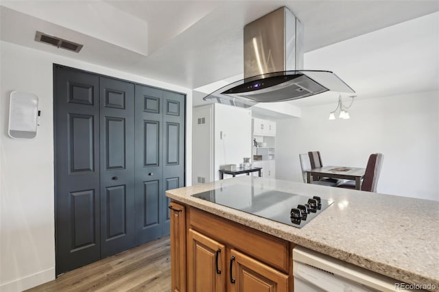 12455 W Alameda Dr, Lakewood, CO 80228 - kitchen featuring black electric cooktop, island range hood, dishwasher, brown cabinetry, and light wood-style floors