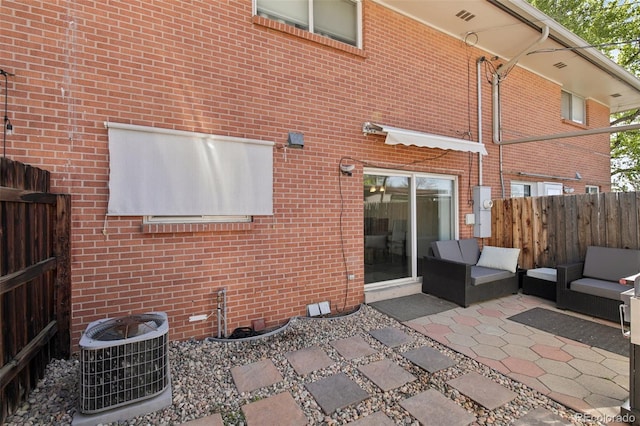 12455 W Alameda Dr, Lakewood, CO 80228 - rear view of property featuring fence, central air condition unit, brick siding, and a patio area