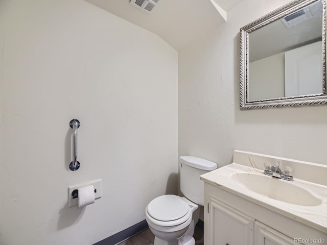 bathroom featuring vanity, toilet, and vaulted ceiling