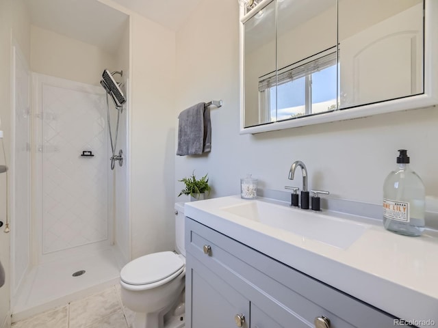 bathroom featuring vanity, toilet, a tile shower, and tile patterned floors