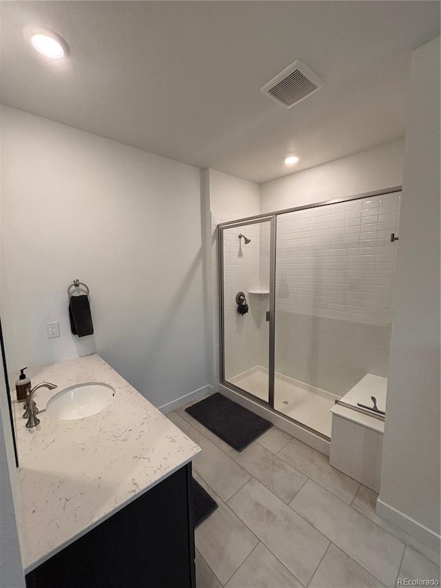 bathroom with tile patterned floors, a shower with door, and vanity