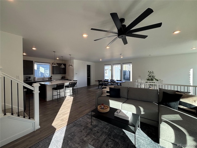 living room featuring ceiling fan and dark hardwood / wood-style floors