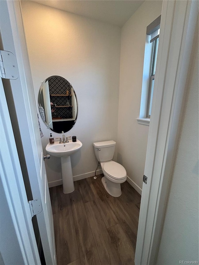 bathroom featuring wood-type flooring and toilet