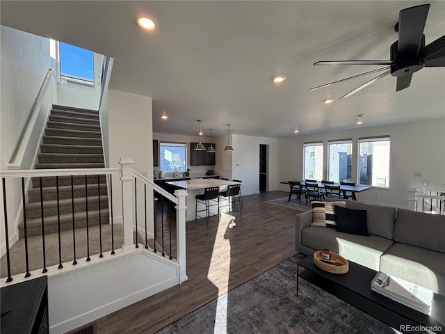 living room featuring ceiling fan and dark wood-type flooring